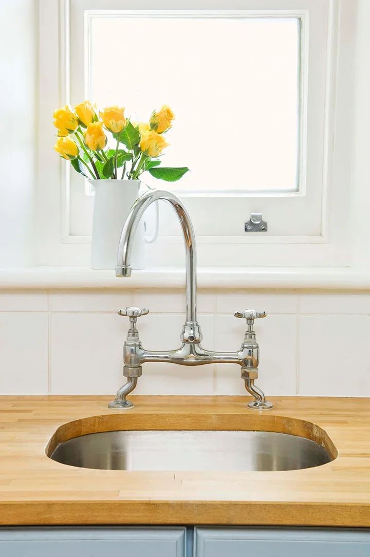 a photo of a kitchen sink and faucet to explain how to open a jar with hot water