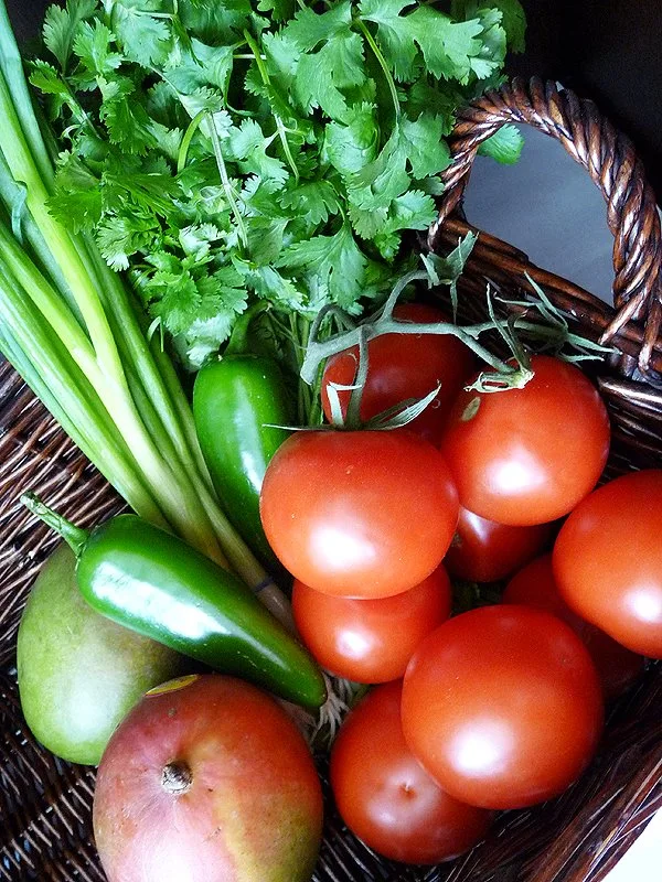 photo of ingredients to make tomato mango salsa in a basket