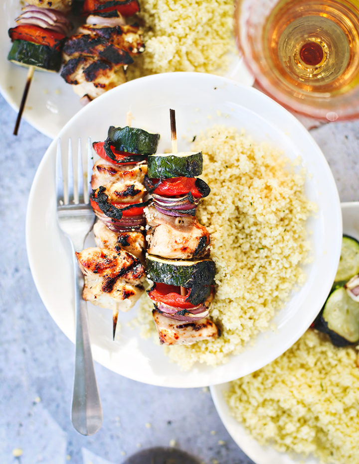 photo of grilled chicken kebabs: plates of couscous with grilled honey lemon garlic chicken and veggies