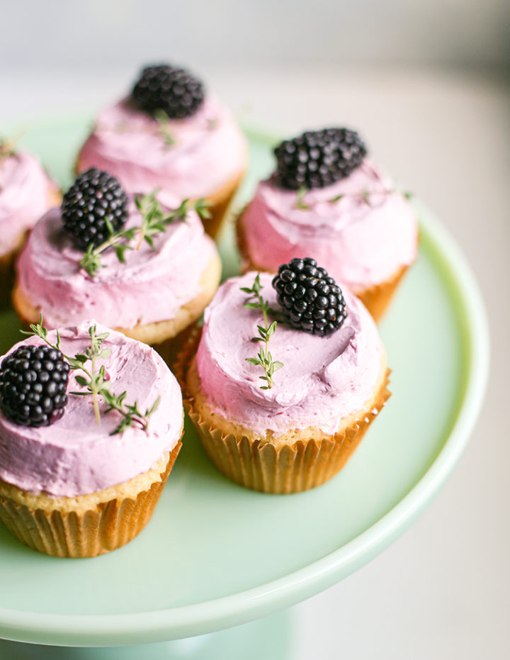 photo of lemon blackberry cupcakes with blackberry buttercream on a cake stand