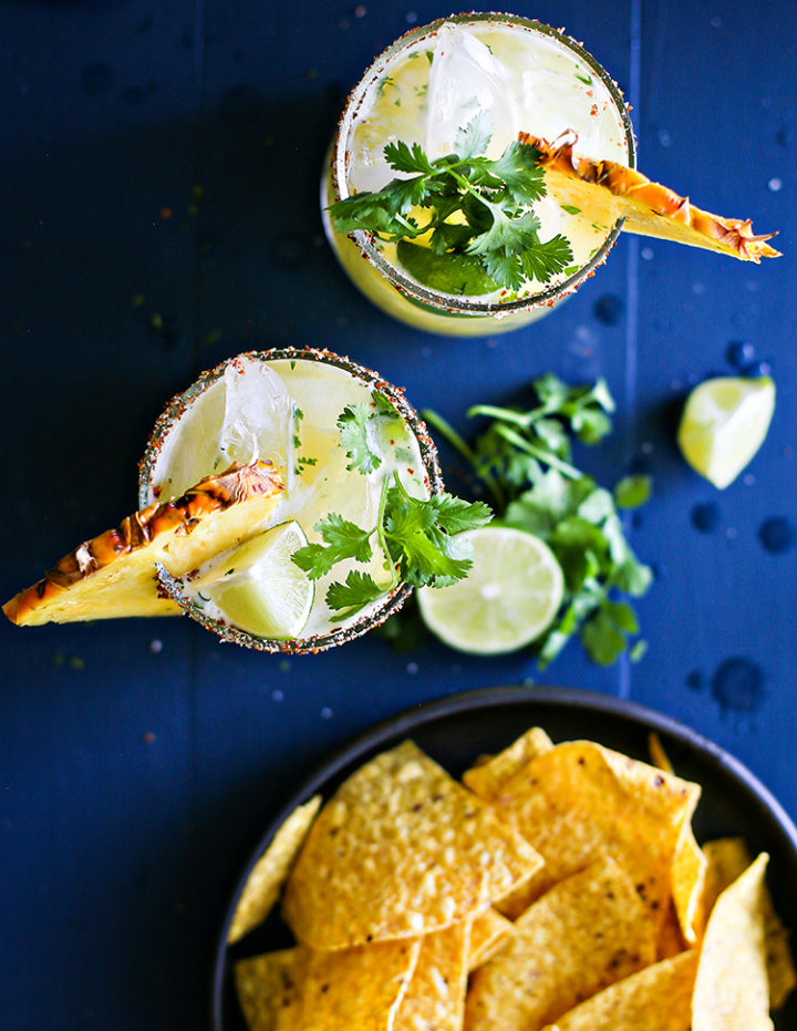 overhead photo of two pineapple margaritas with a spicy salt rim