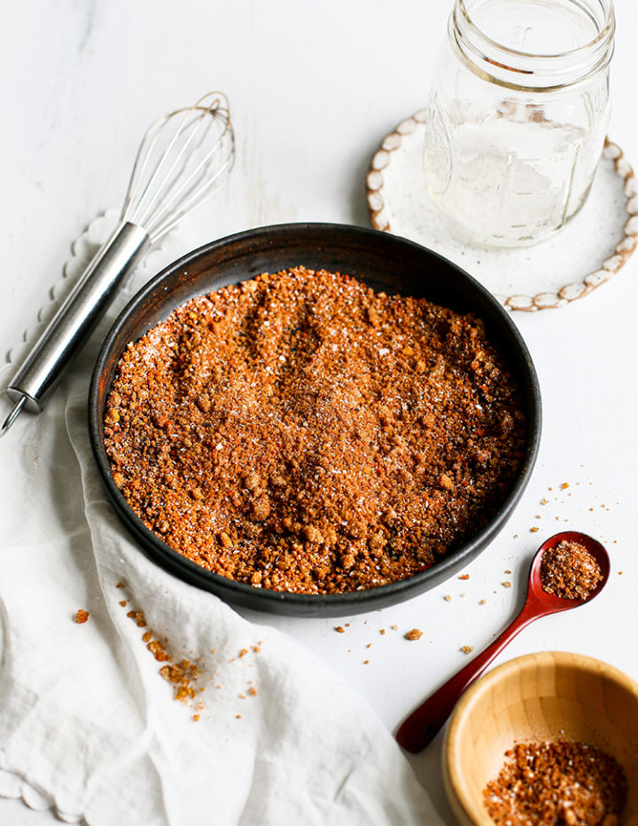 photo of homemade dry rub for chicken in a black bowl with a spoon and jar