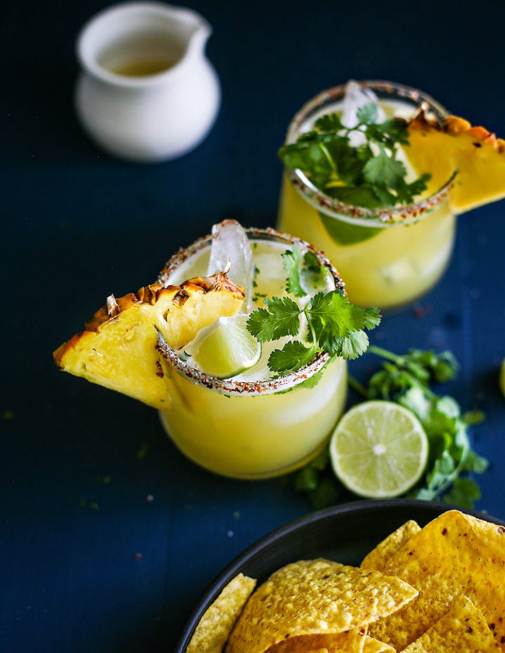 pineapple margaritas on a dark blue table