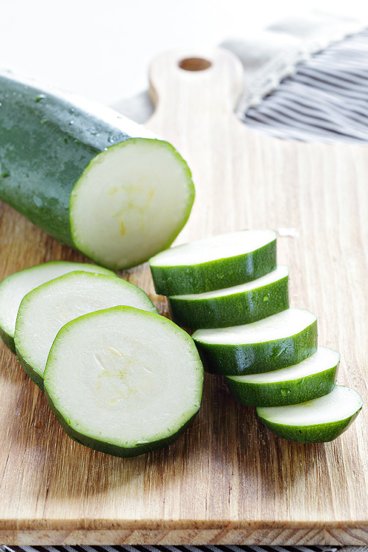 photo of sliced zucchini on a cutting board for freezing