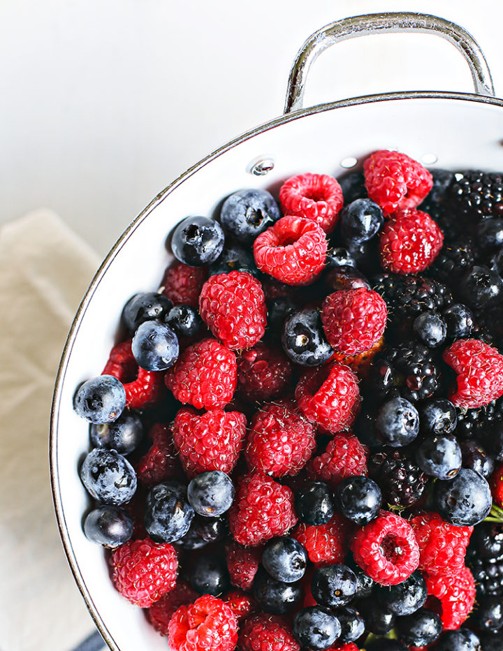 photo of berries in a white colander for a mixed berry galette