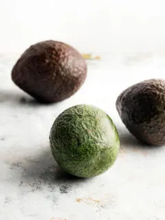 photo of avocados on a light surface for a tutorial on how to freeze avocados