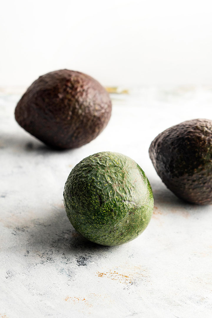 photo of avocados on a light surface for a tutorial on how to freeze avocados