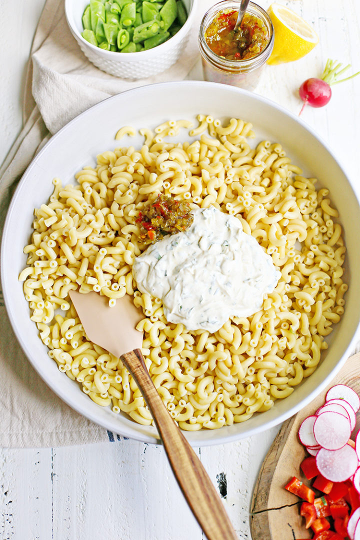 overhead photo of mixing the tangy dressing into macaroni salad