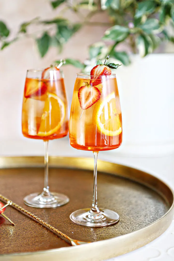 close up photo of 2 glasses of strawberry aperol spritz with garnish