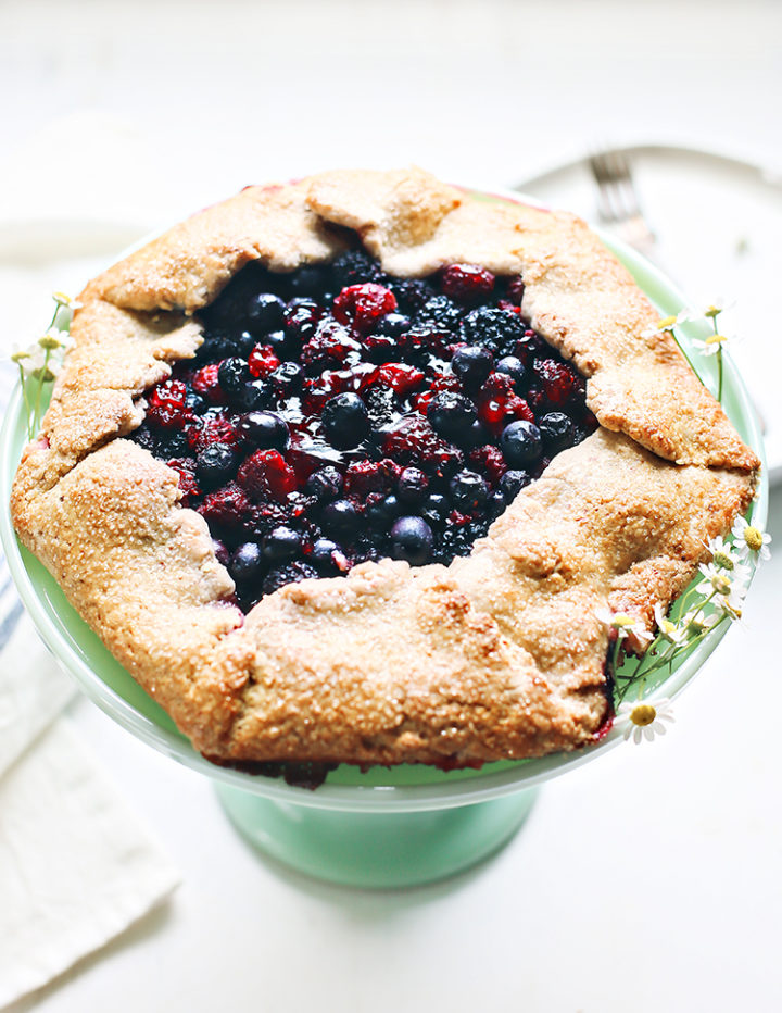 photo of a mixed berry galette on a cake stand