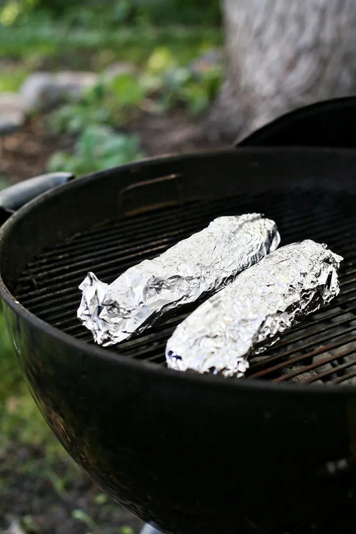 photo of foil wrapped corn being grilled