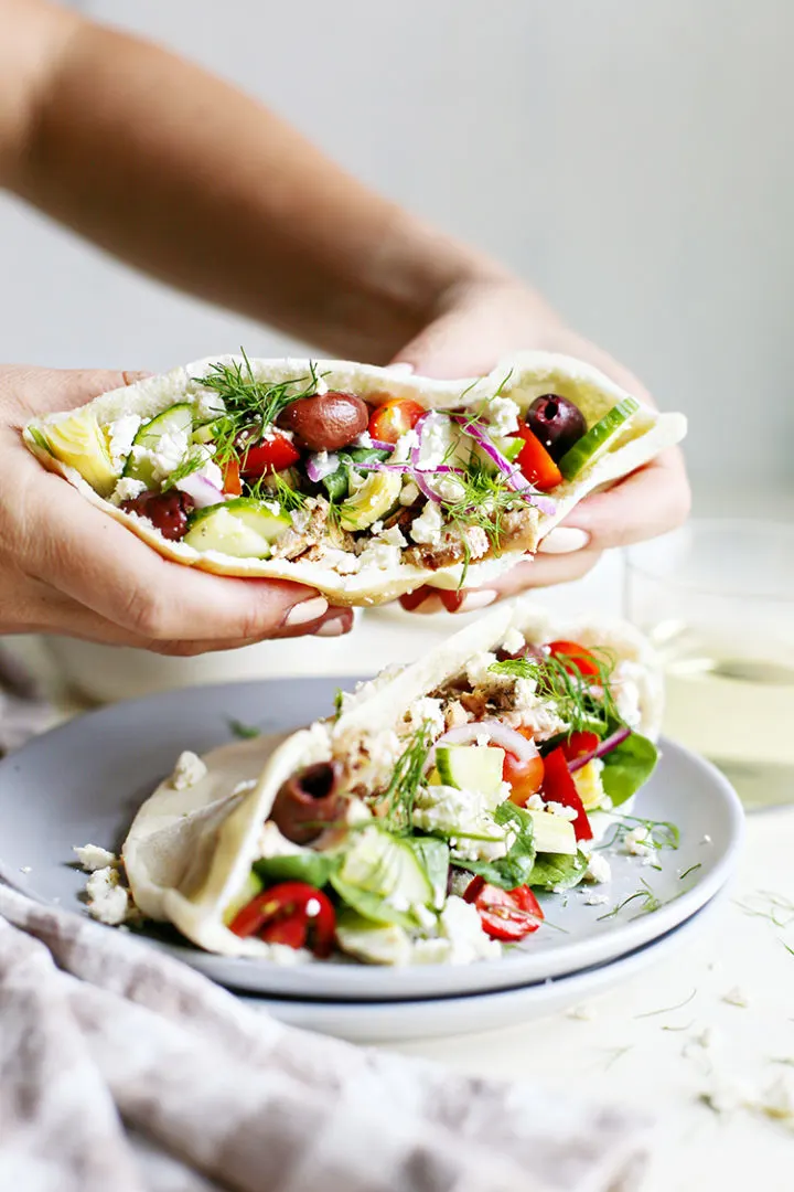photo of a woman eating greek chicken pitas
