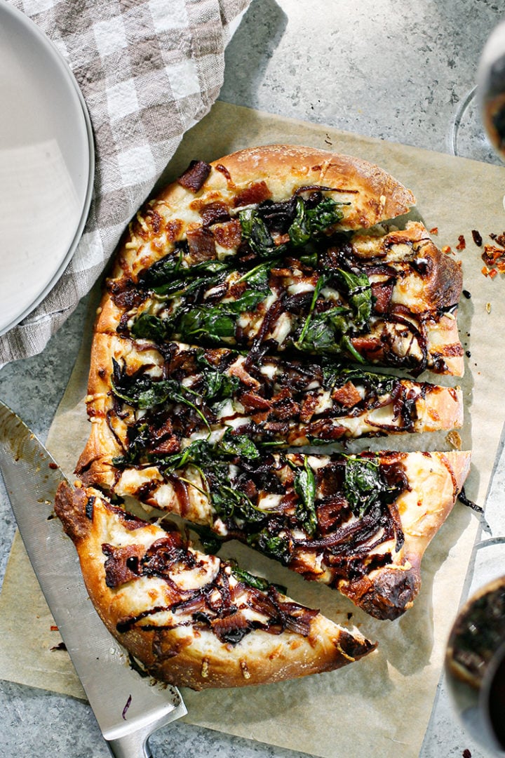 photo of slices of Bacon Pizza with Caramelized Onion on a sheet of parchment paper