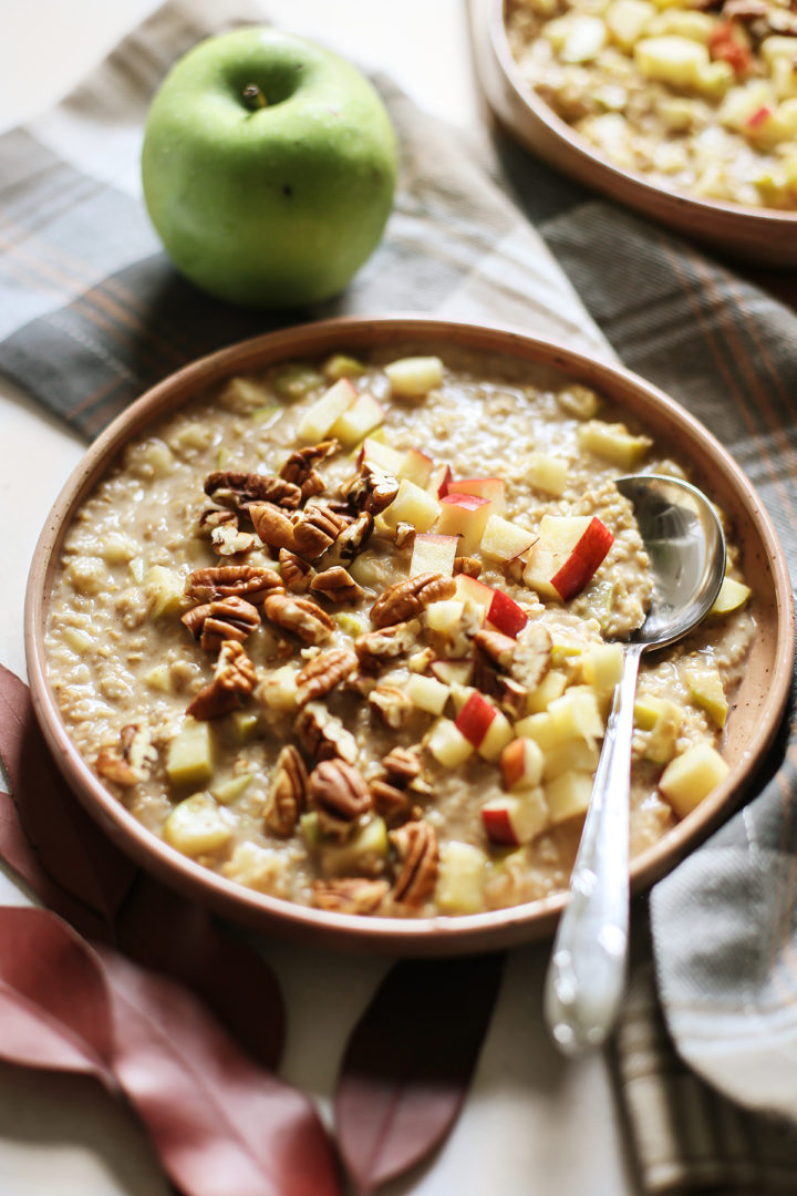 close up photo of a bowl of apple overnight oats with chopped apples and pecans on top