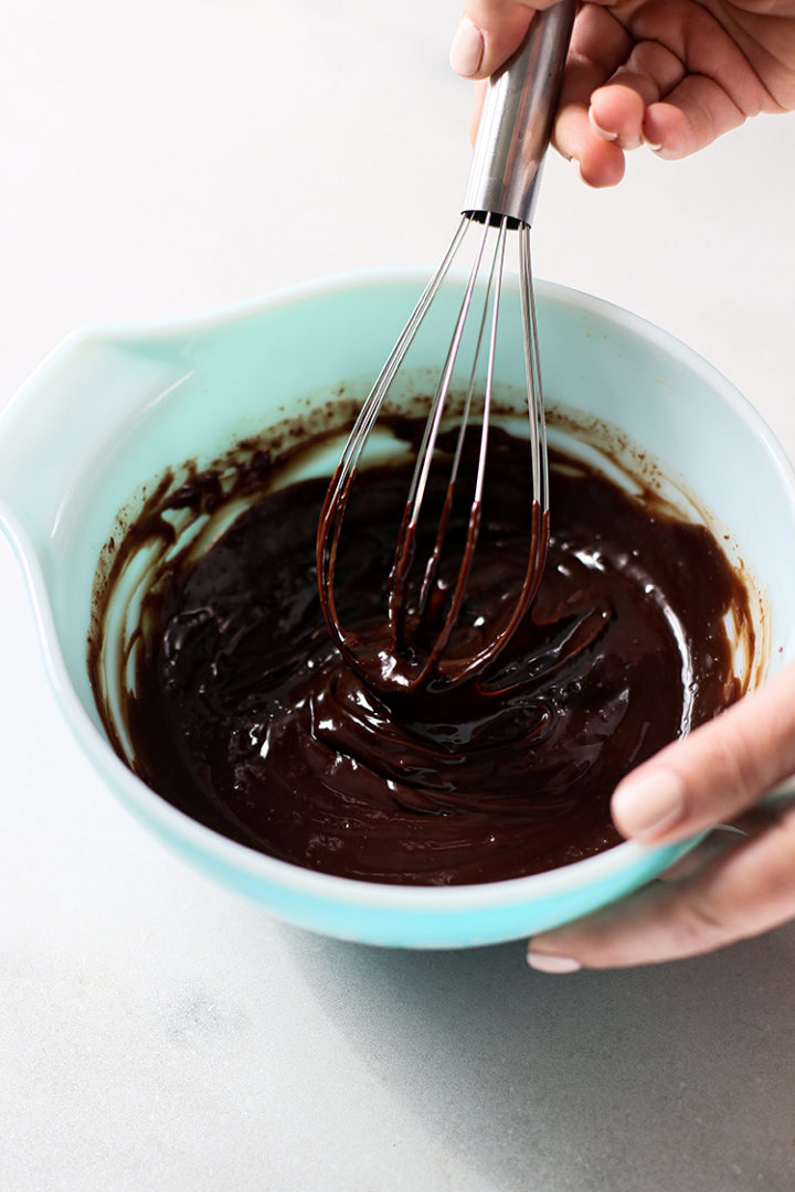 photo of woman making chocolate coating for pumpkin truffles