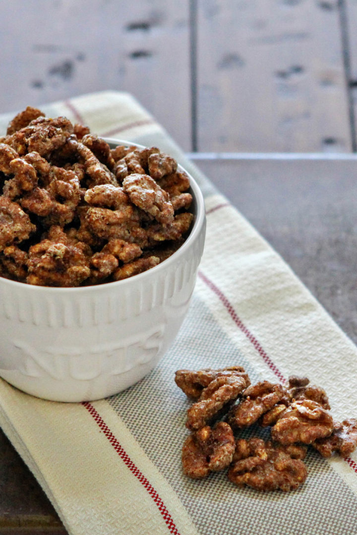 photo of cinnamon vanilla glazed walnuts in a white bowl on a wooden table