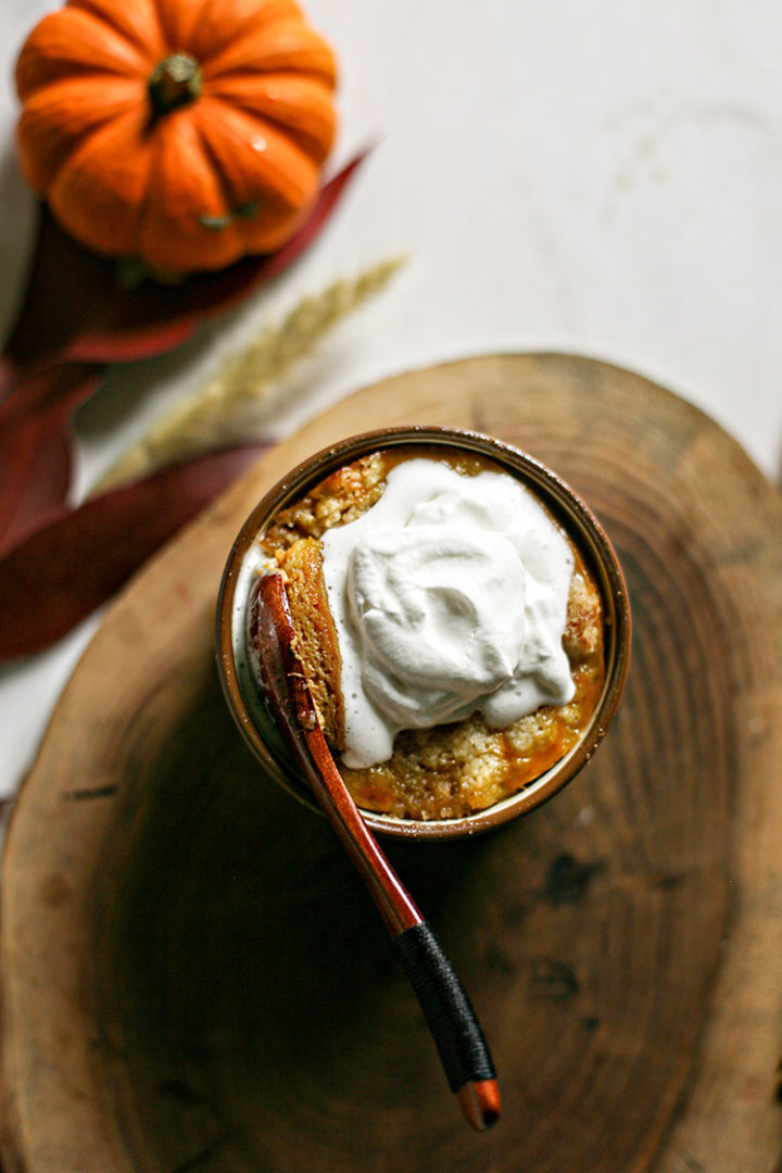 photo of a single serving of pumpkin pie cobbler with a spoonful of whipped cream on top