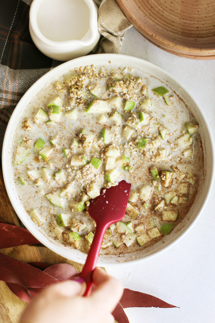 photo of a woman stirring the ingredients in this recipe for apple overnight oats