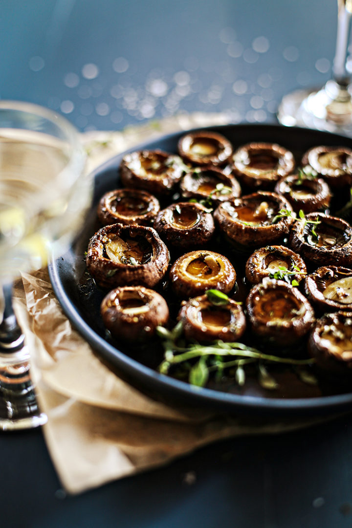 photo of roasted portobello mushrooms on a serving plate on a dark blue table being served as an easy appetizer