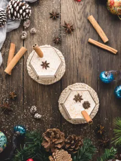 overhead photo of two glasses of spiked eggnog on a wooden table