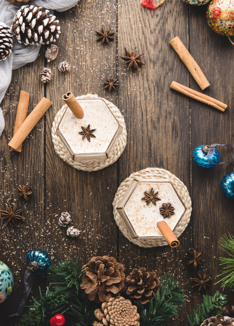 overhead photo of two glasses of spiked eggnog on a wooden table