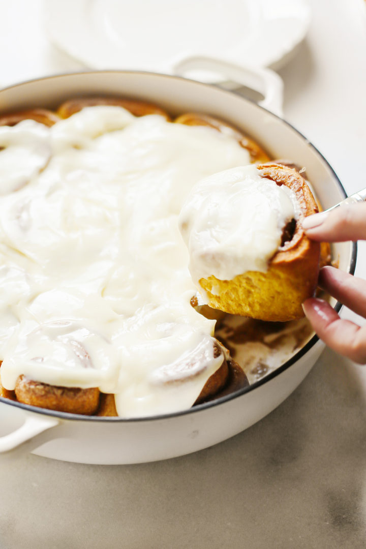 photo of woman serving pumpkin cinnamon rolls