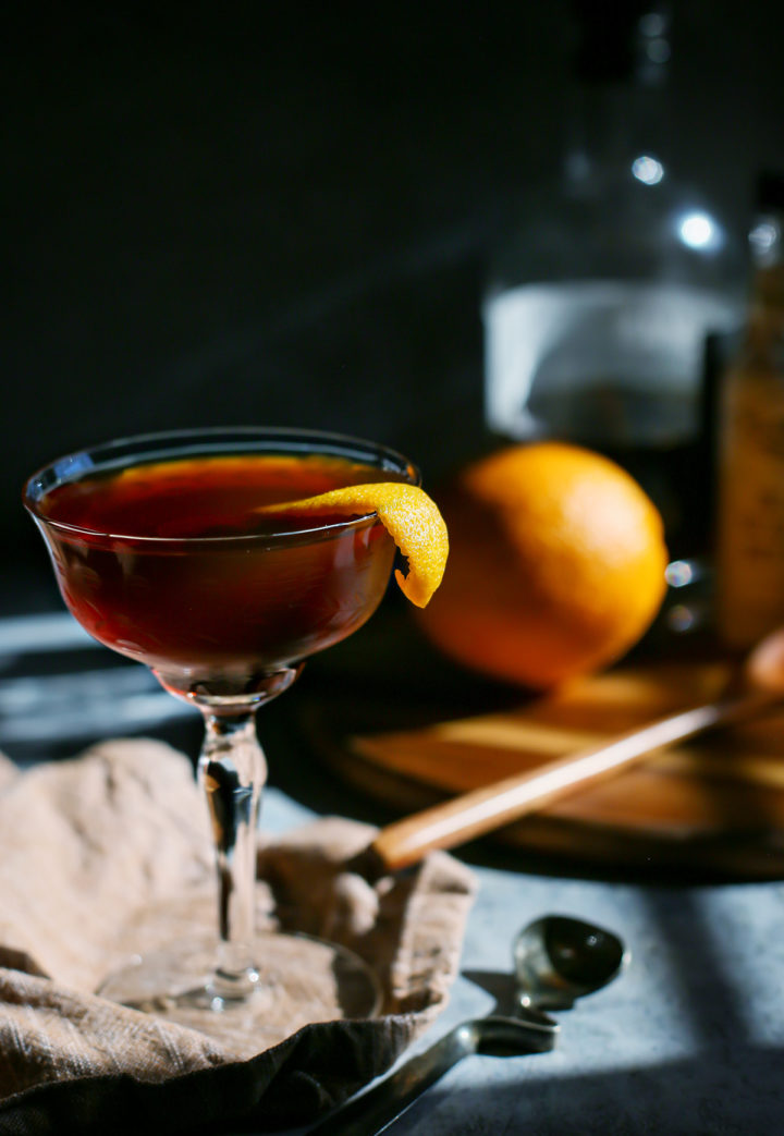 photo of a black manhattan in a coupe glass in a dark room