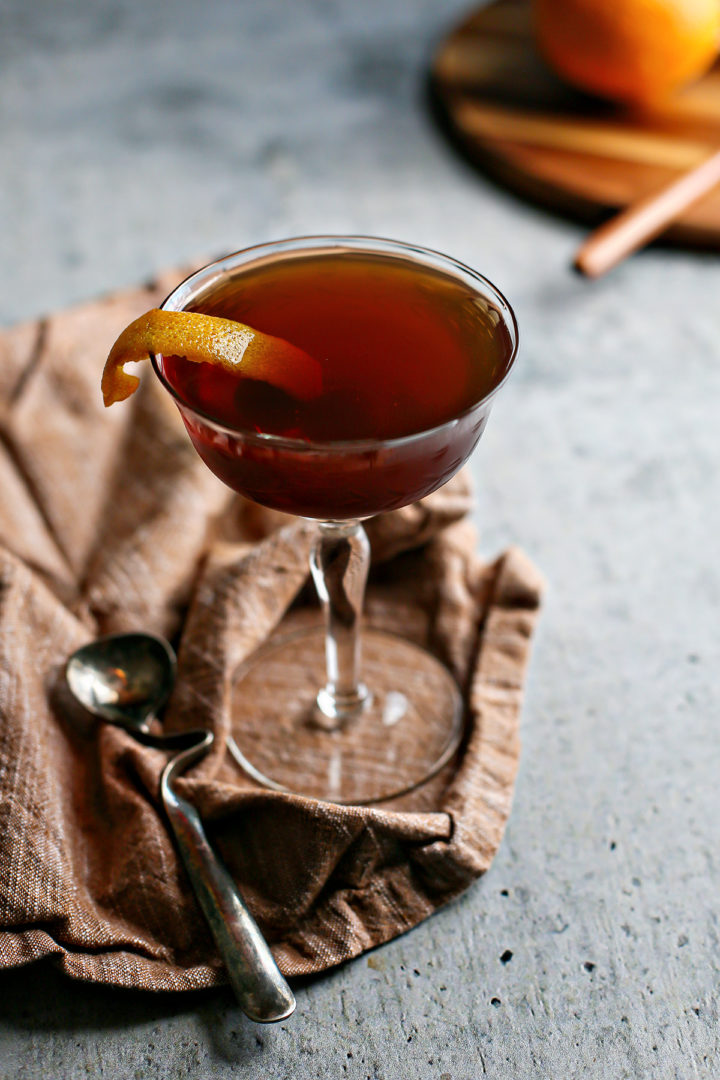 photo of a black manhattan cocktail on a bar counter