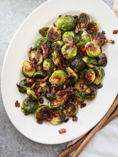 photo of roasted brussel sprouts with bacon on a white serving platter