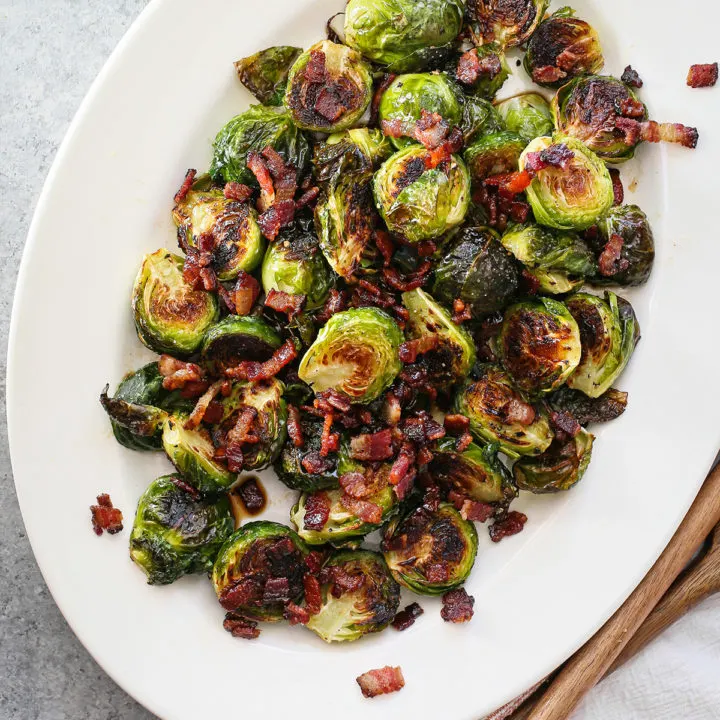 photo of roasted brussel sprouts with bacon on a white serving platter