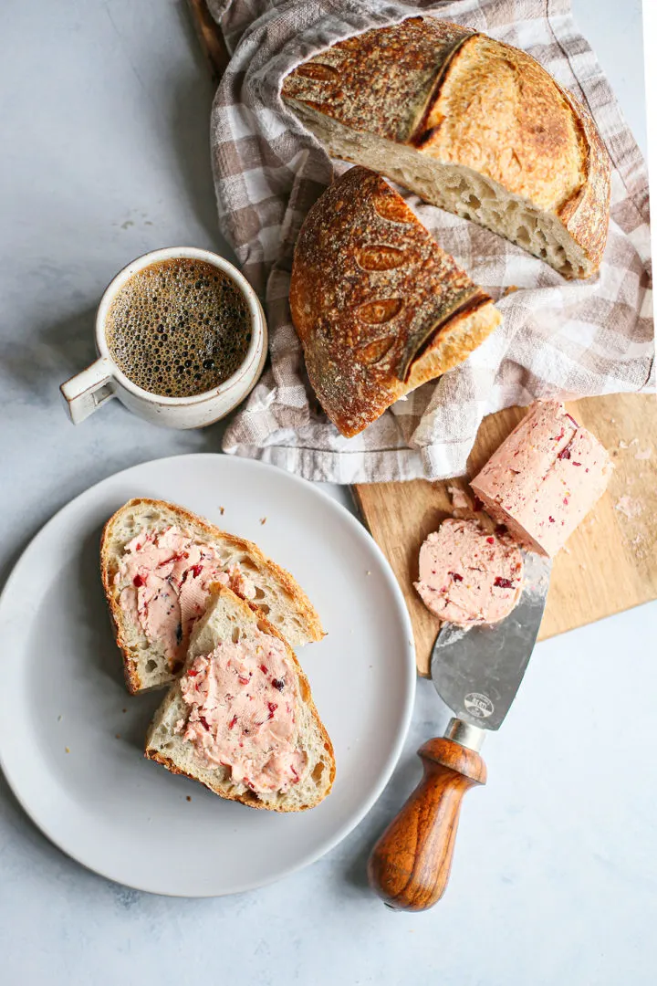 photo of a plate with sliced bread spread with cranberry butter and a cup of coffee
