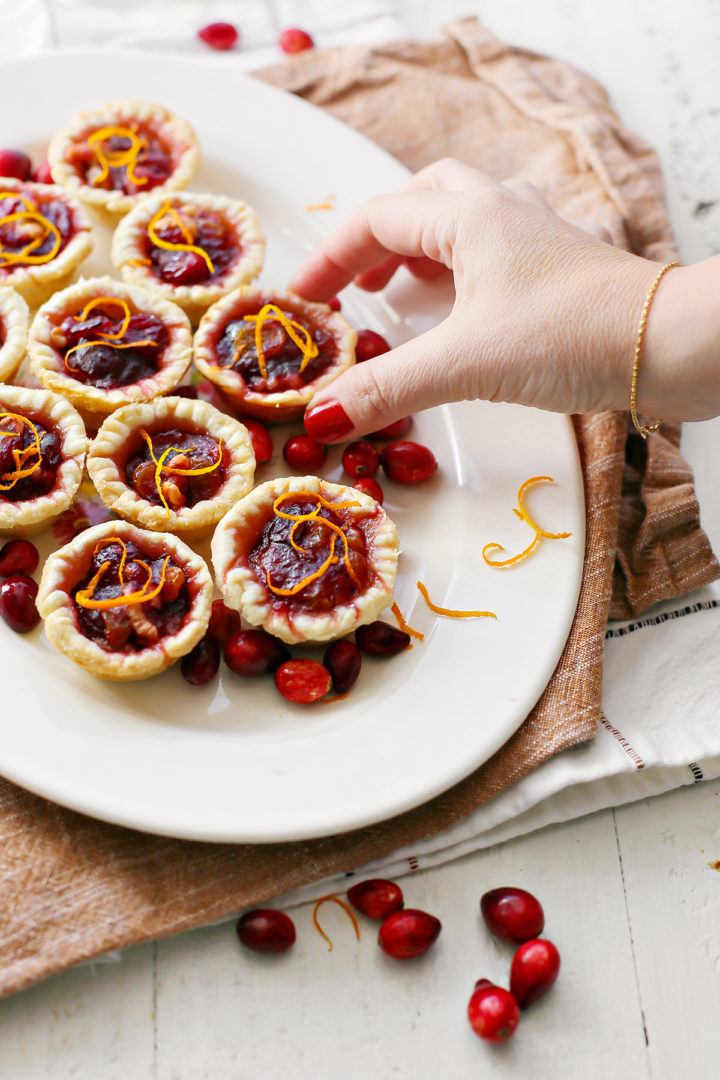 photo of a woman eating mini cranberry tarts