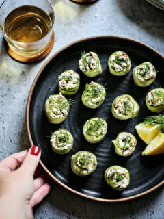 cucumber rolls ups on a black plate