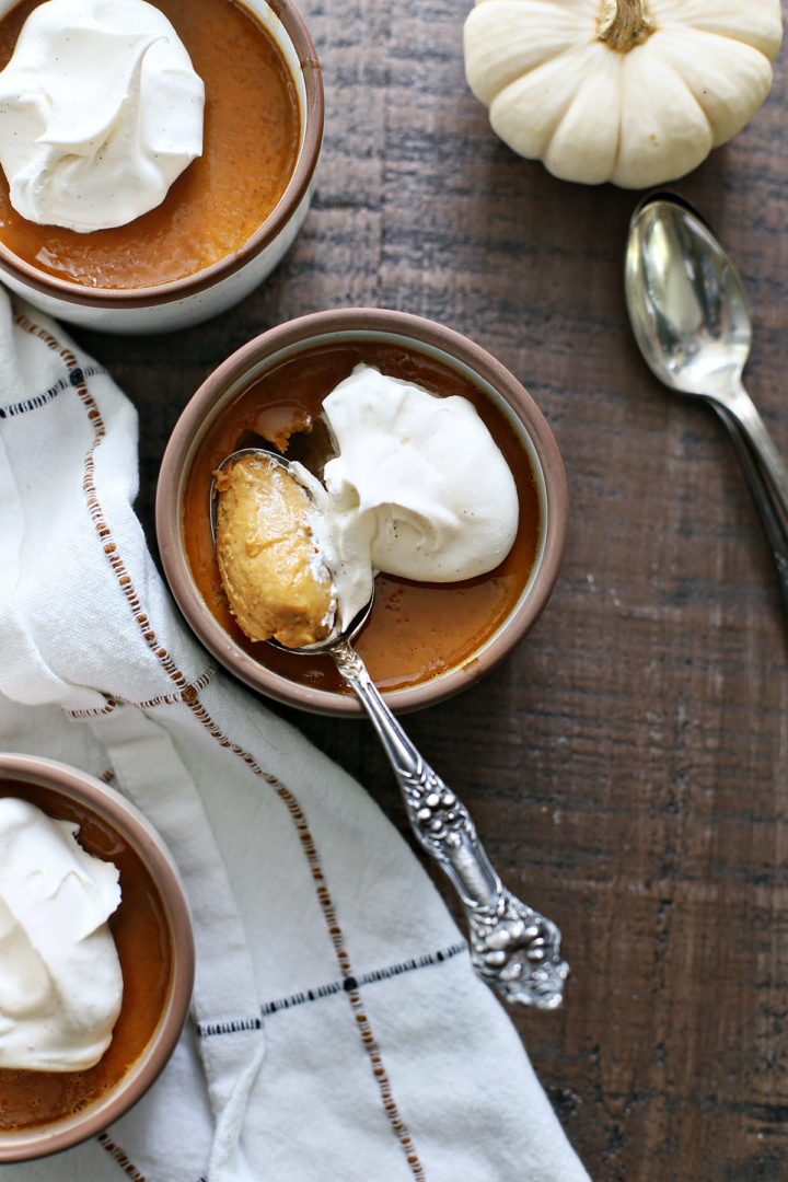 overhead photo of a bowl of pumpkin custard being eaten with a spoon