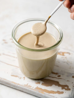 photo of a jar of homemade tahini with a spoon