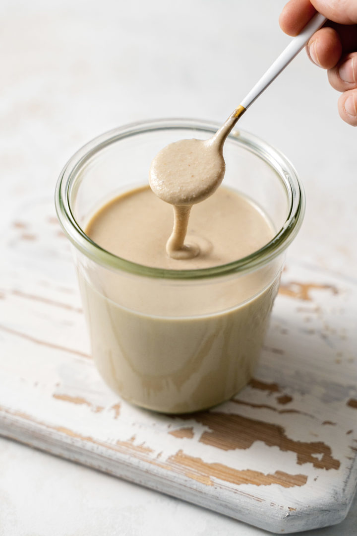 photo of homemade tahini in a jar with a spoon