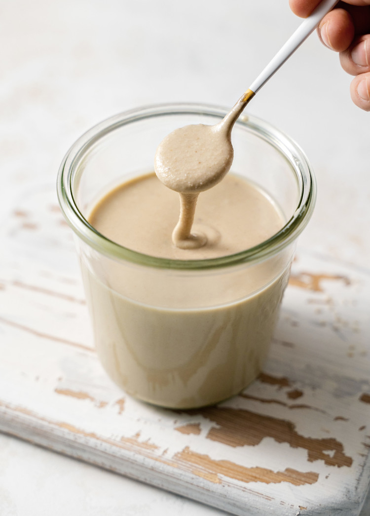 photo of a jar of homemade tahini with a spoon