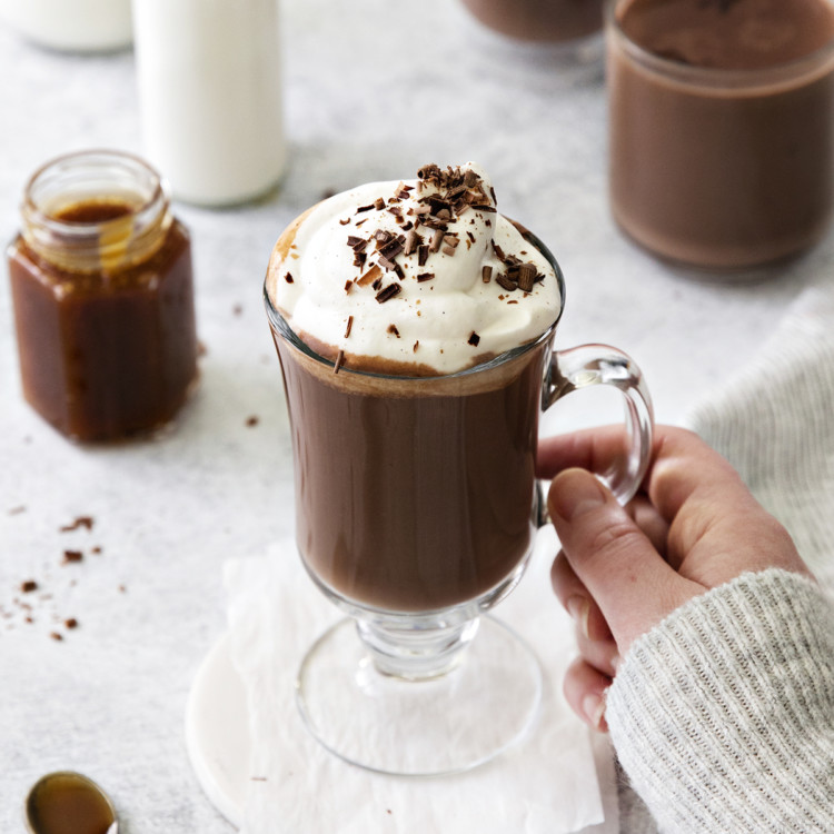 woman holding a mug of salted caramel hot chocolate