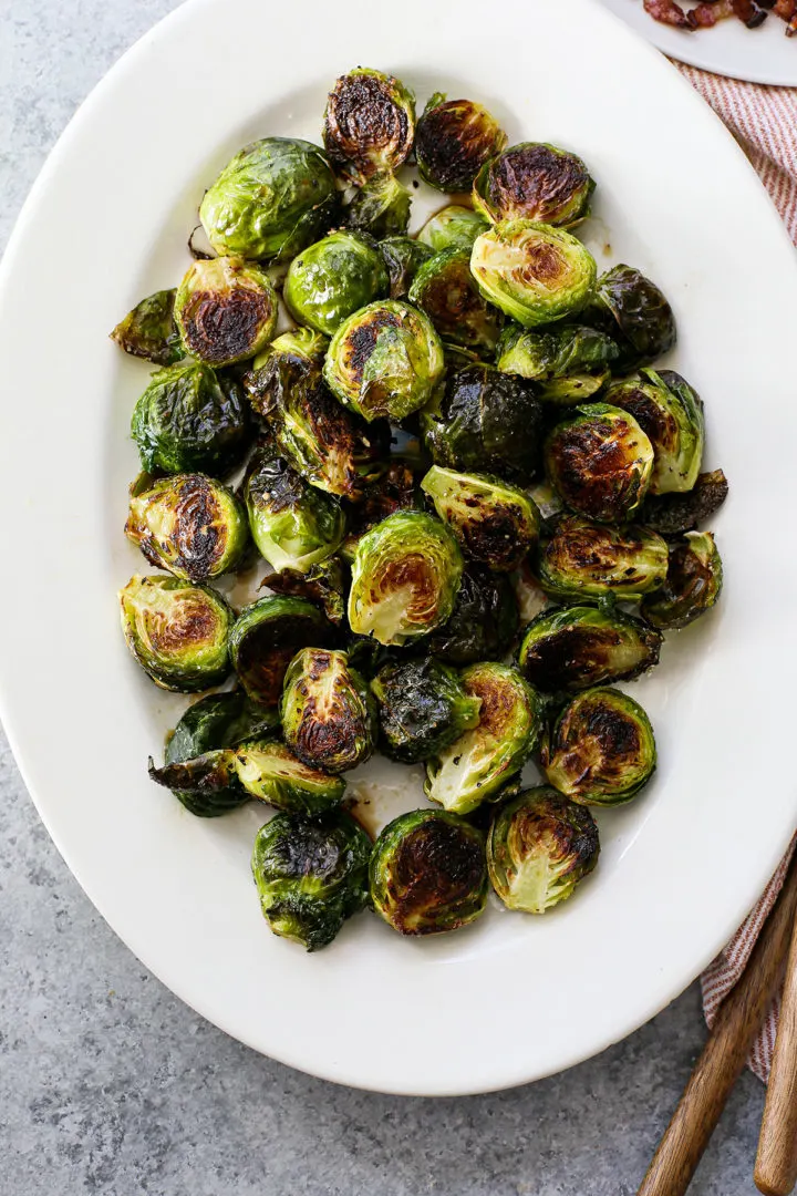 photo of balsamic drizzled crispy brussels sprouts on a white platter