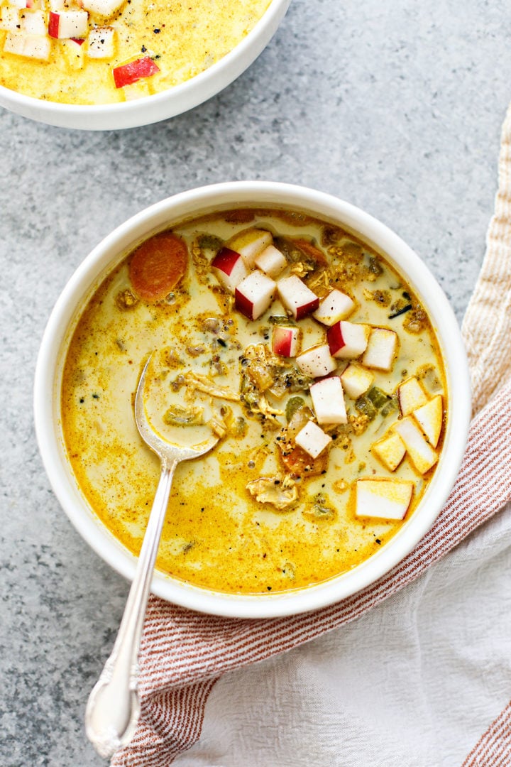 two bowls of turkey curry on a grey surface