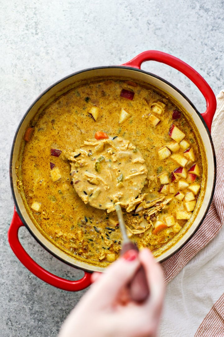 woman stirring a pot of spicy turkey soup