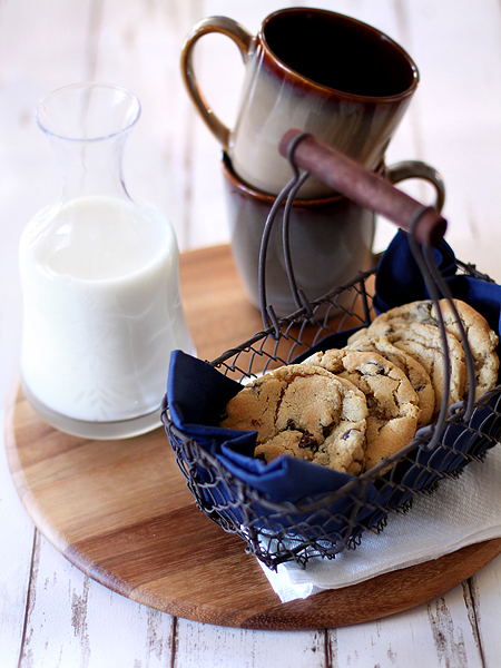 photo of the new york times chocolate chip cookies in a basket with mugs and container of milk