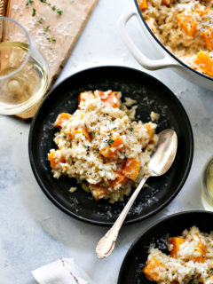 butternut squash risotto on a black plate on a table
