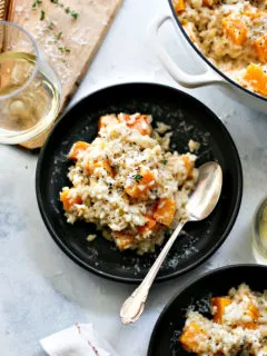 butternut squash risotto on a black plate on a table