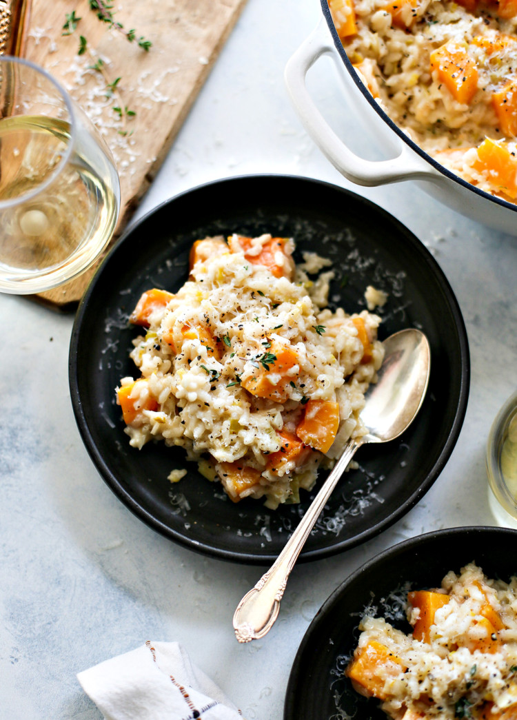 butternut squash risotto on a black plate on a table