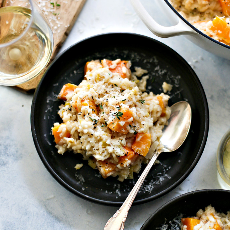 butternut squash risotto on a black plate on a table