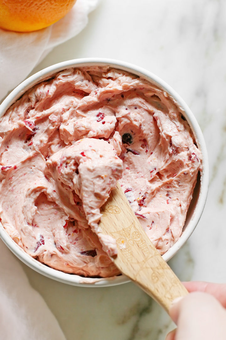 overhead photo of cranberry butter in a white bowl on a marble counter