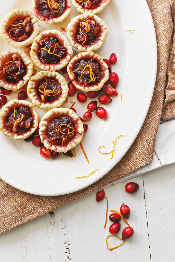 overhead photo of cranberry tartlets on a white serving platter