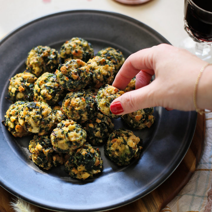 photo of woman with a plate of spinach balls