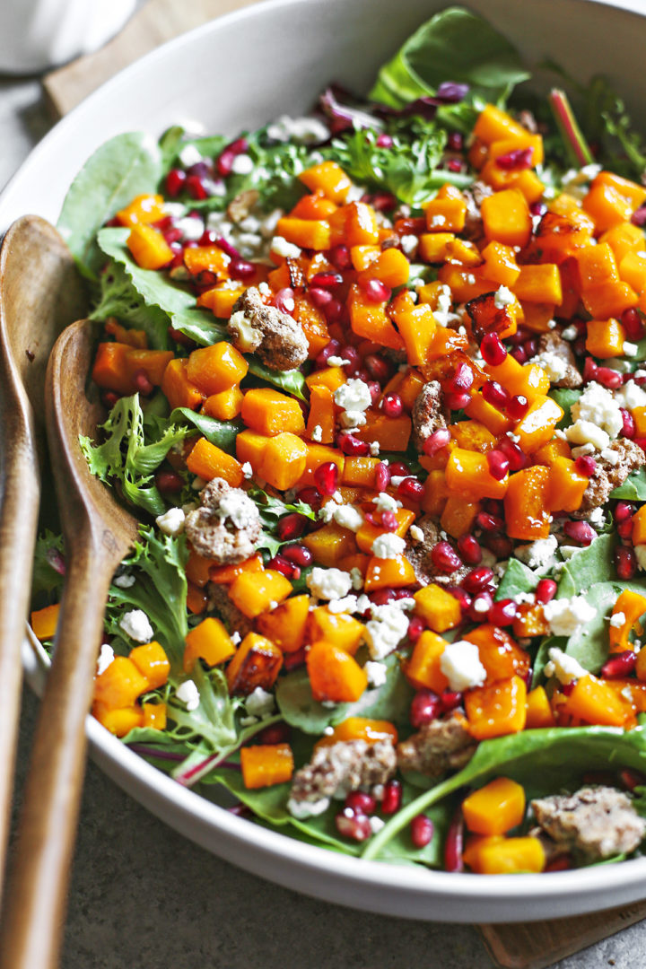 close up photo of butternut squash salad with wooden salad tongs